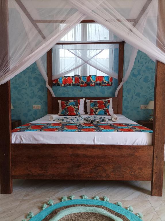 a bedroom with a bed with a canopy at Zanzicrown in Nungwi