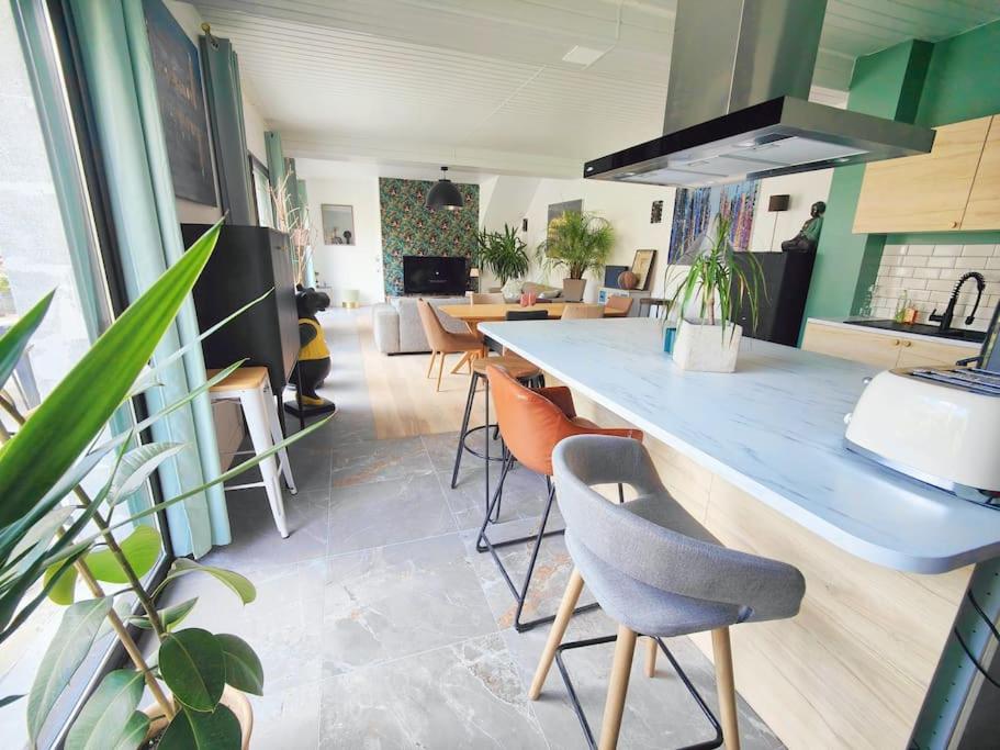 uma cozinha com um balcão azul e algumas cadeiras em La parenthèse rémoise 
