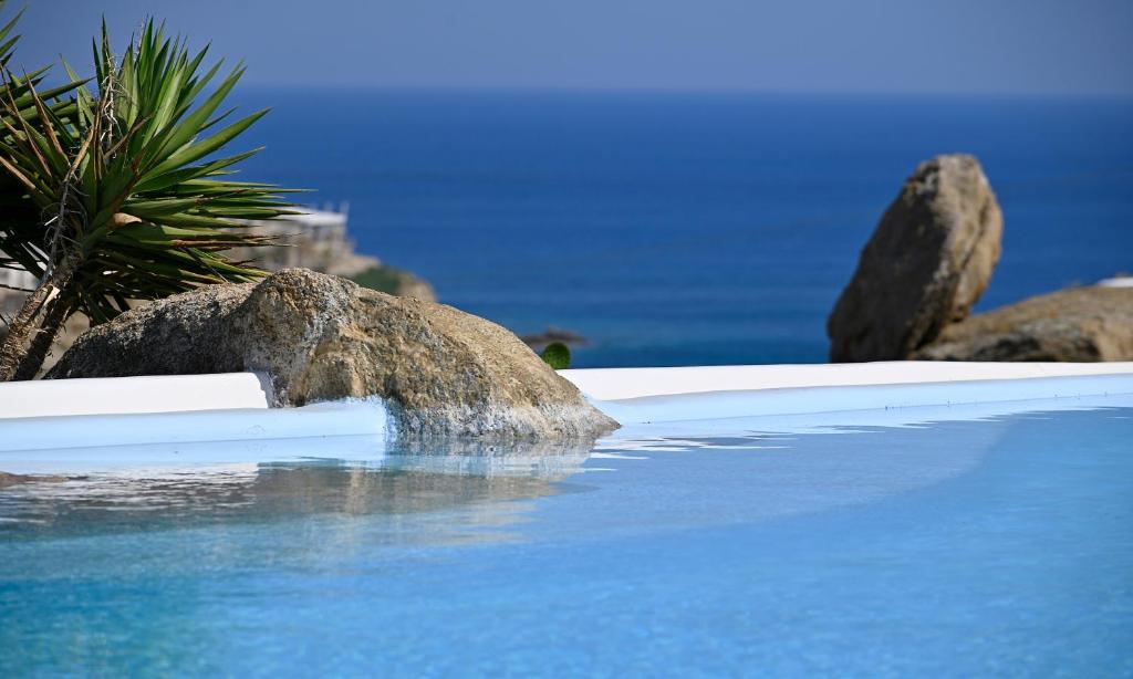 una piscina con rocas y agua azul en 7 bedrooms villa at Platis Gialos 800 m away from the beach with sea view private pool and enclosed garden en Paradise Beach