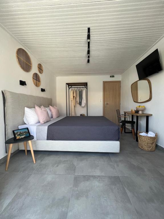 1 dormitorio con cama, mesa y TV en Australia en Skiathos