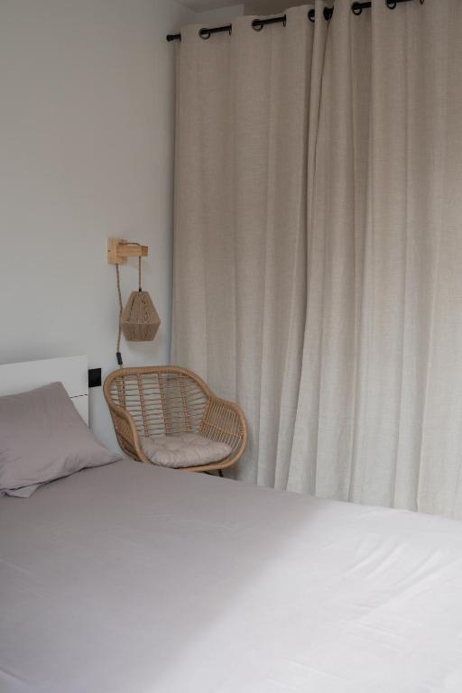 - une chambre avec un lit et une chaise à côté d'une fenêtre dans l'établissement Appartement 2 pièces Montpellier centre, à Montpellier