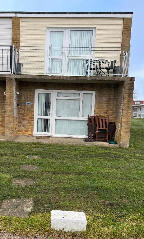 a house with two chairs sitting on the front porch at 114 Bermuda in Hemsby