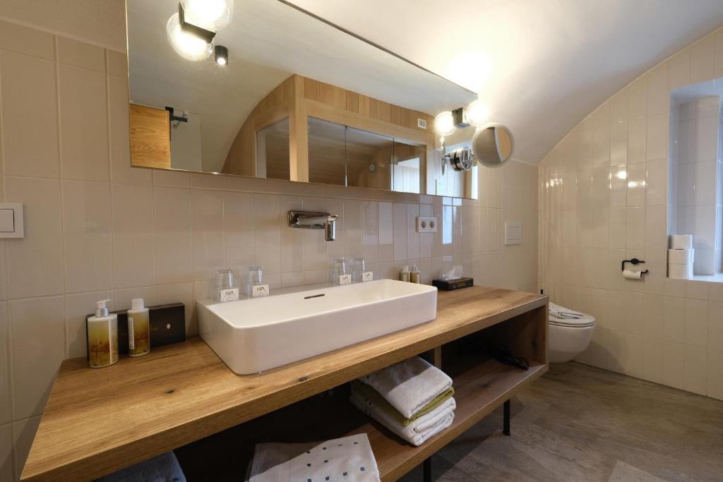 łazienka z białą umywalką i toaletą w obiekcie SeeHotel & SeeApartments Kärntnerhof- direkt am See! w mieście Weissensee