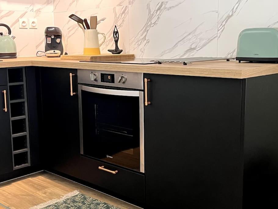 - une cuisine avec un comptoir et un four dans l'établissement # Charme, Calme & Cosy # Brive #, à Brive-la-Gaillarde