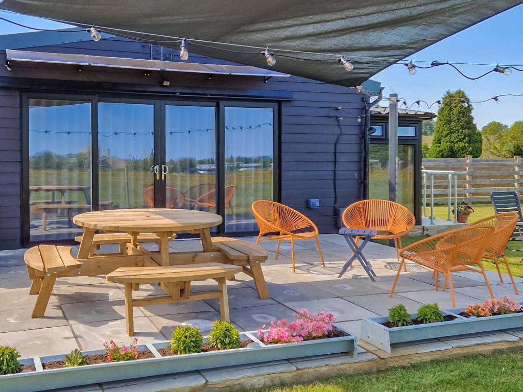 a patio with a picnic table and chairs at The Goat Shed in Hadlow