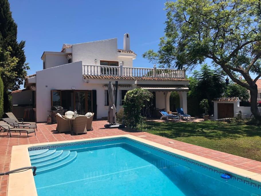 eine Villa mit einem Pool vor einem Haus in der Unterkunft La fuenta in Málaga