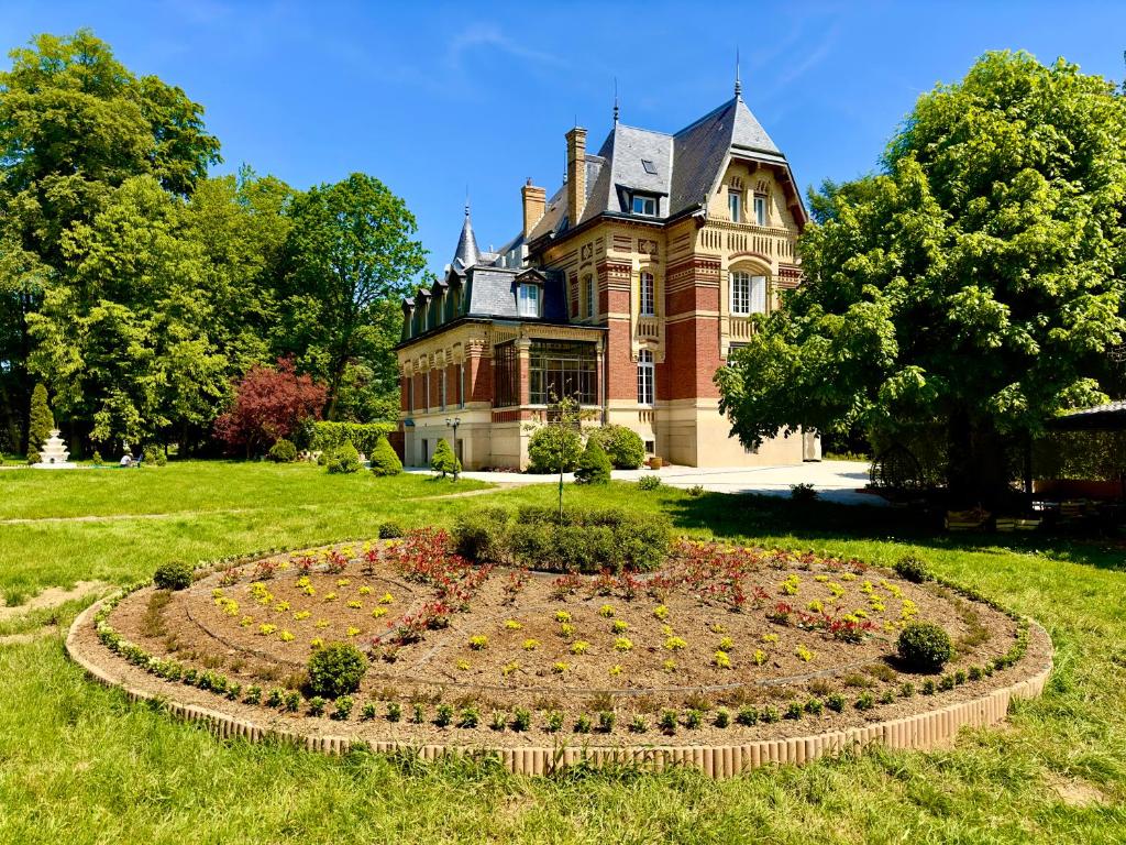 una casa antigua con un jardín delante de ella en Château de Moliens, en Moliens