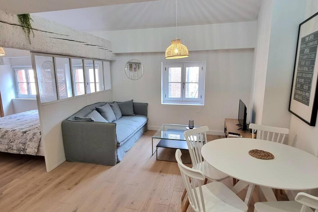 un salon avec un canapé et une table dans l'établissement Dans les nuages - T2 Spacieux Standing - Metro - Wifi, à Toulouse