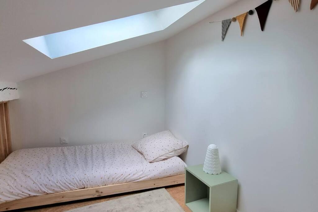 a bedroom with a bed and a skylight at Dans les nuages - T2 Spacieux Standing - Metro - Wifi in Toulouse