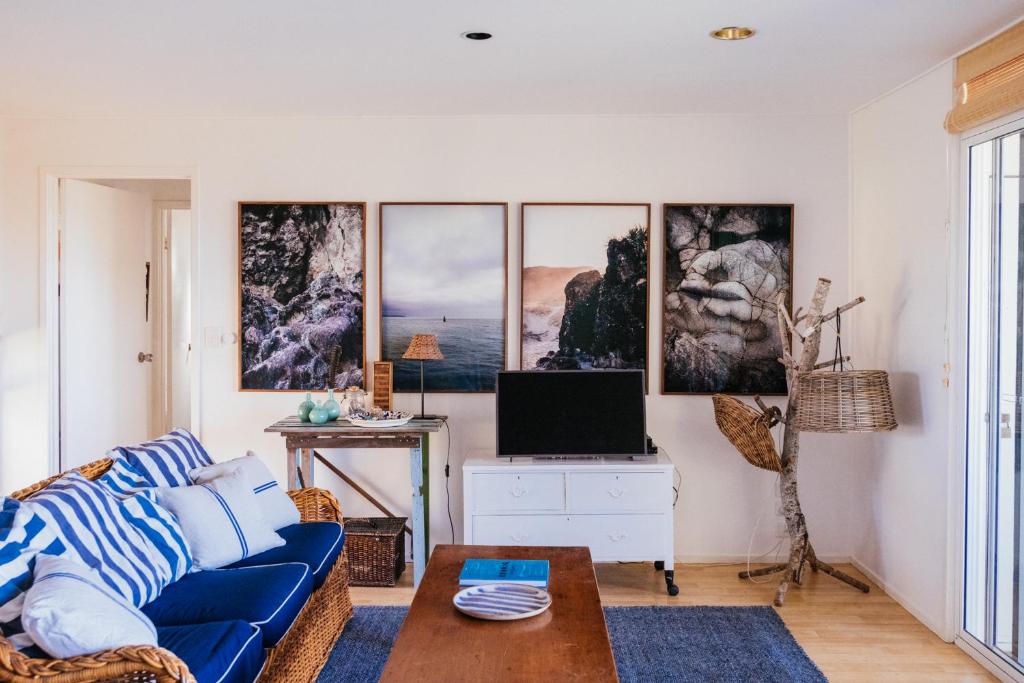 a living room with a blue couch and pictures on the wall at Hillhouse in Point Lookout