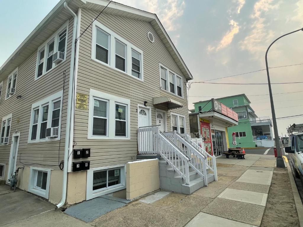 Una gran casa con una escalera blanca delante de ella en Dupont Beach House B en Seaside Heights