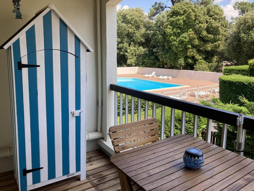 uma porta azul e branca num alpendre com uma mesa e uma piscina em Joli Studio em Grand-Village-Plage