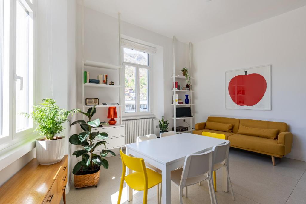 sala de estar con mesa blanca y sillas amarillas en Lago Design Guest House - Como Center, en Como