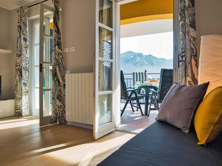 una sala de estar con una puerta que da a un balcón en La Breva apt. Lake Como Bellagio, en Magreglio