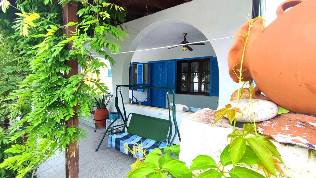 Una habitación con una pared azul y blanca y plantas. en House SOFIA MILIES, en Stavros