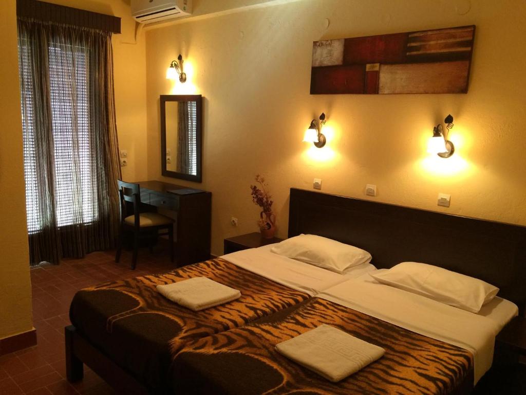 um quarto com uma cama grande com duas toalhas em Green Hotel - Maravel Botanical Garden em Spílion