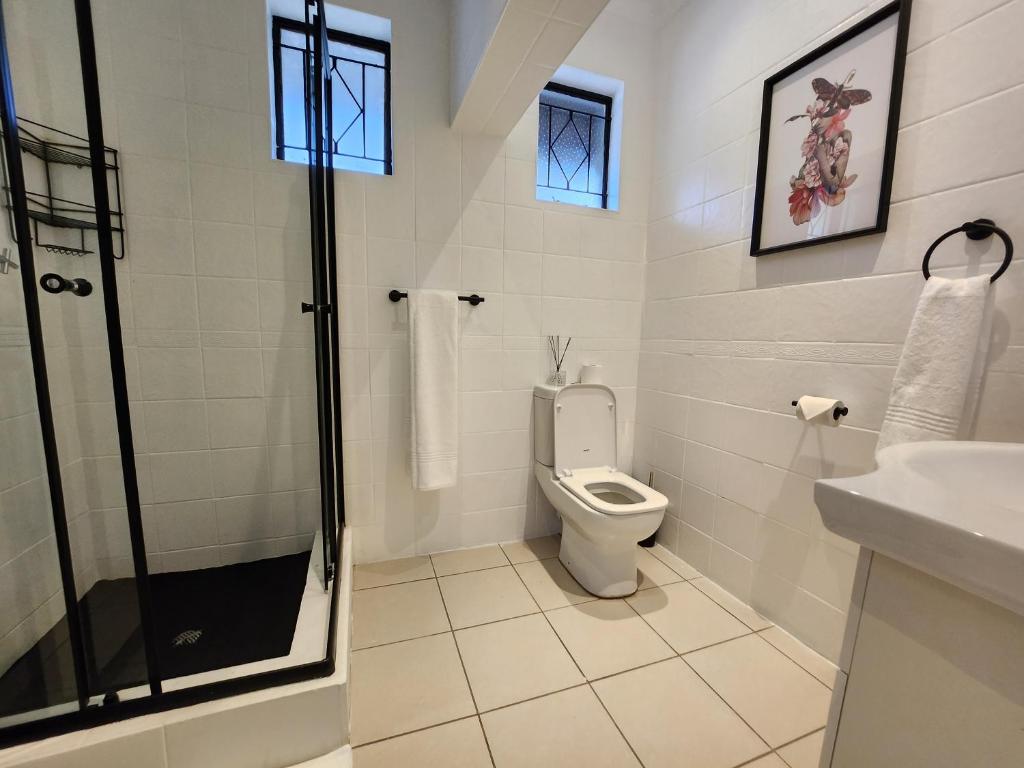 a bathroom with a toilet and a shower and a sink at 136 on 4th in Johannesburg