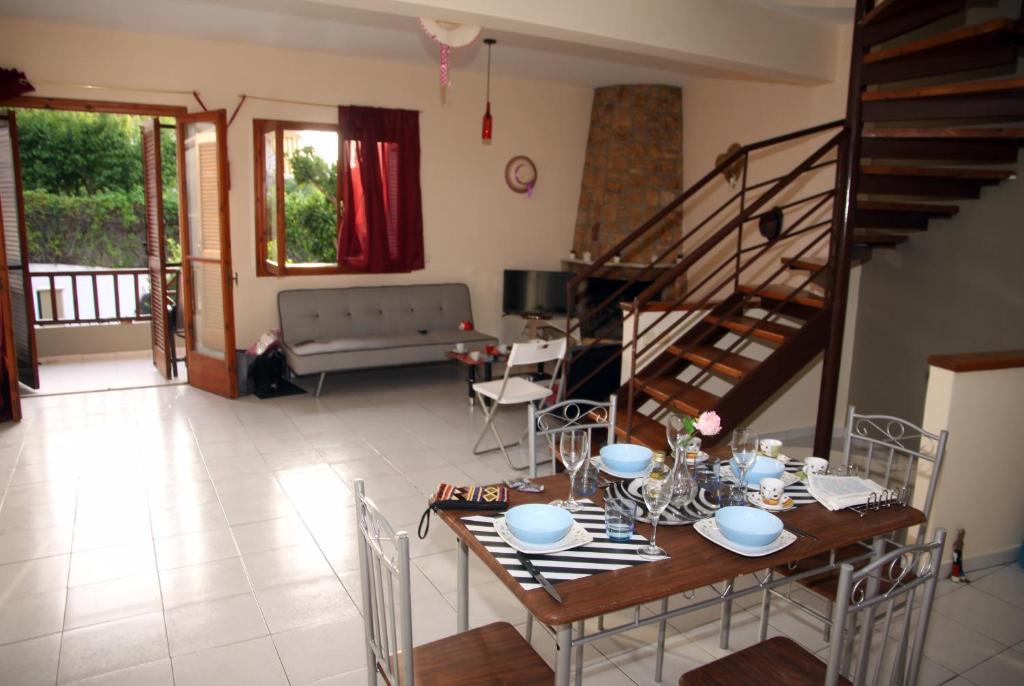uma sala de estar com uma mesa e cadeiras e uma escadaria em Villa Olympia Skafidia em Skafidia