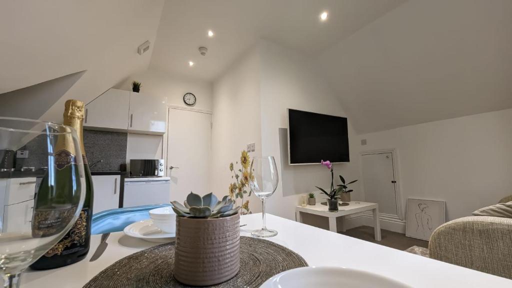 una cucina e un soggiorno con tavolo e bicchieri da vino di Modern spacious apartment a Brighton & Hove