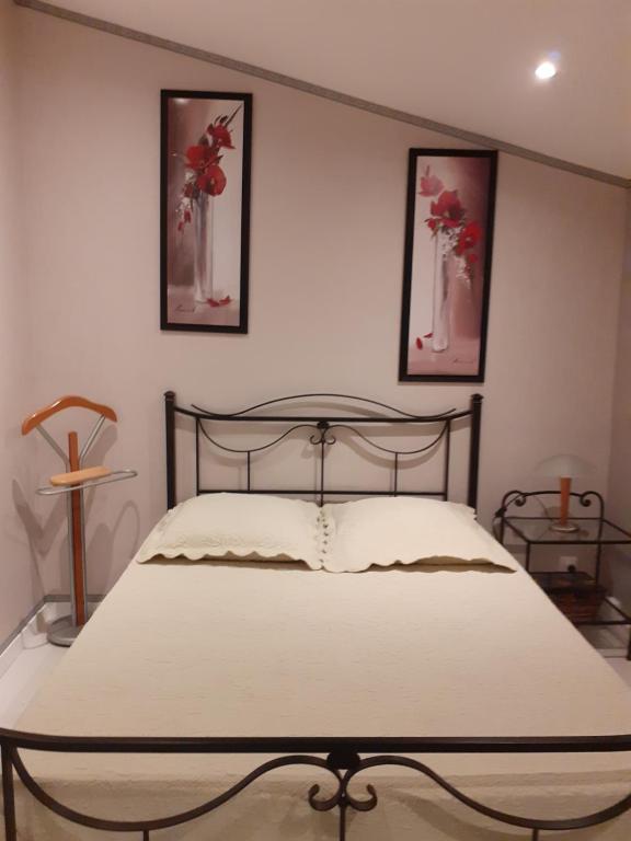 的住宿－Chambre coquelicots chaleureuse dans un écrin verdoyant，卧室配有一张墙上有两张照片的床。