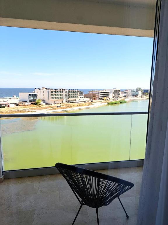 a bench sitting in front of a large window at Apartamente Vista Lago e Mare in Eforie Nord