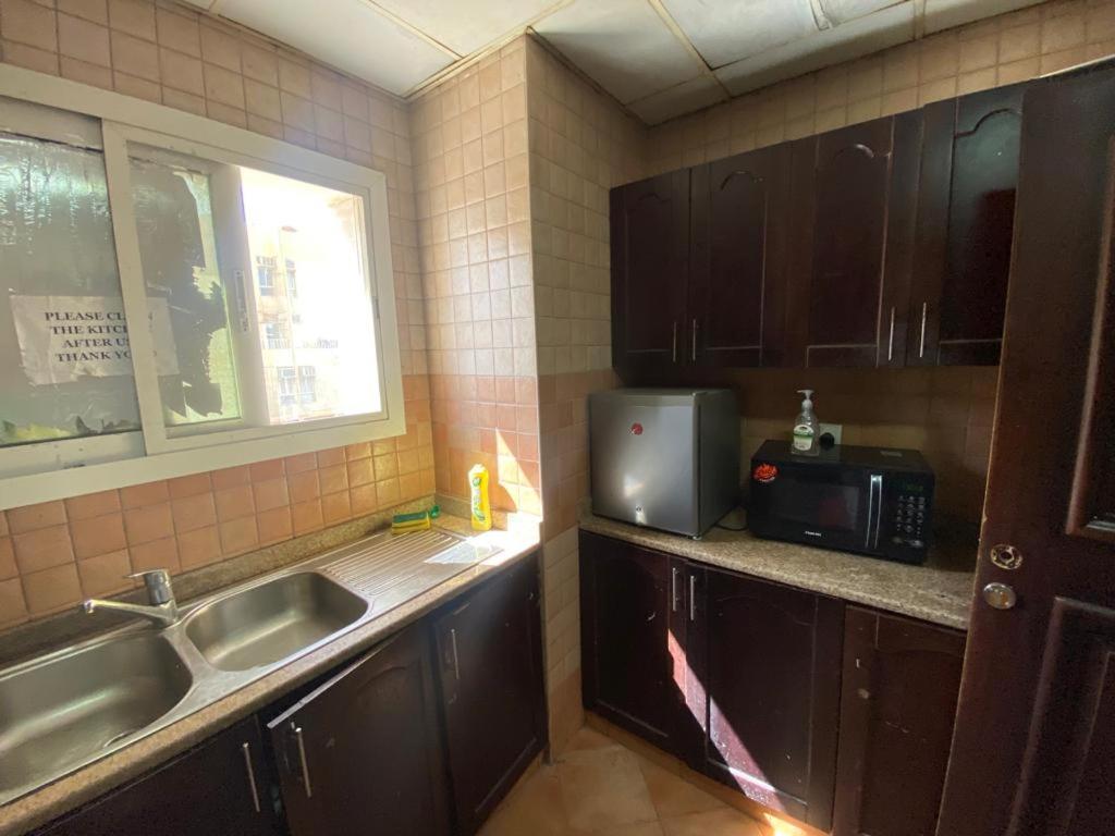 a kitchen with a sink and a microwave at Low-Priced Budget Rooms for rent near Dubai DAFZA in Dubai
