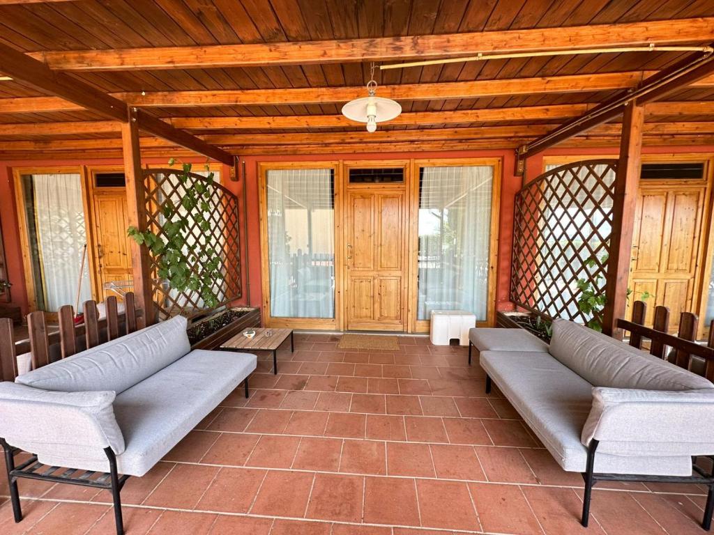 un porche con sofás y sillas en una casa en Villa Ilangi en Lastra a Signa