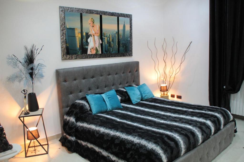 una camera da letto con un grande letto con cuscini blu di Suite Petroni a Bari