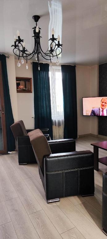 sala de estar con sofá y TV de pantalla plana en Квартира в Батуми, 