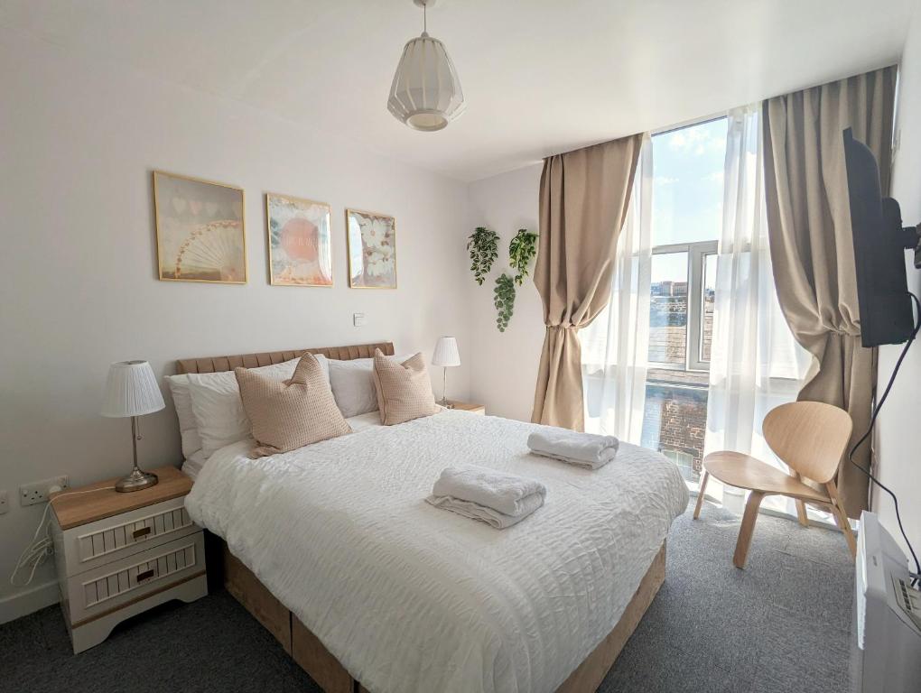 a bedroom with a bed and a large window at City Centre Morden 1-bedroom Apt, Free Parking in Liverpool