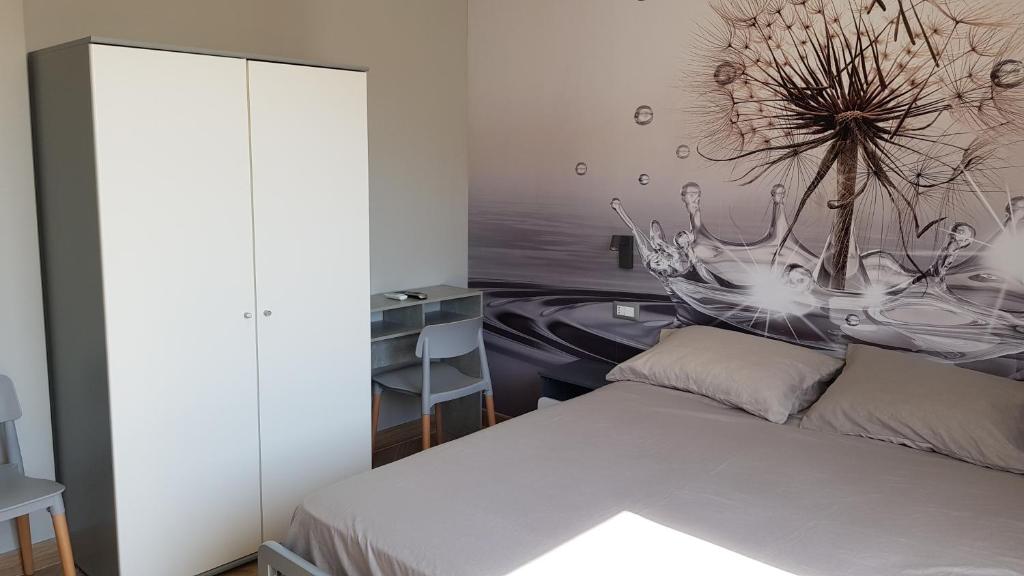 - une chambre avec un lit et une peinture murale dans l'établissement Casalmare Via Asse, à Vintimille
