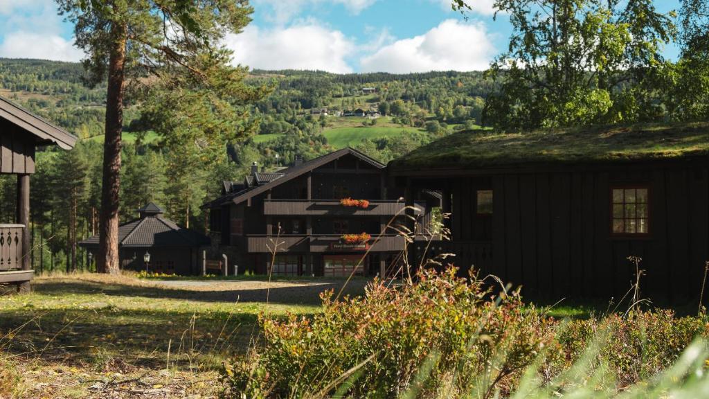 a black house with a grass roof at Hunderfossen Hotel & Resort in Hafjell