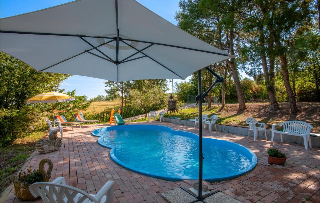 una piscina con sombrilla y sillas en Awesome Home In Piagge With Wifi, 4 Bedrooms And Outdoor Swimming Pool, en Piagge