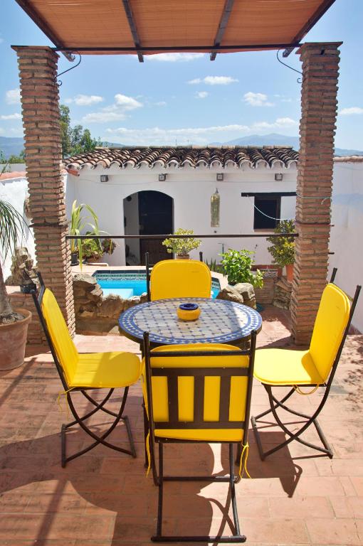 a patio with yellow chairs and a table at Casa Muryo in Jimena de la Frontera