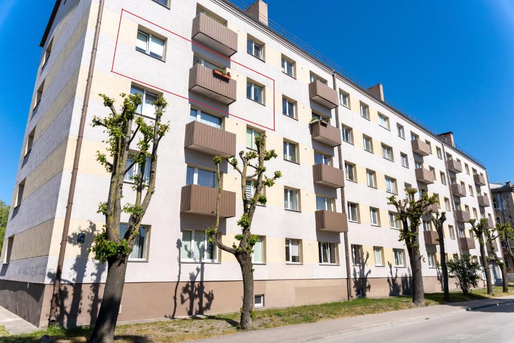 an apartment building with trees in front of it at Nature Love Apartment in Liepāja