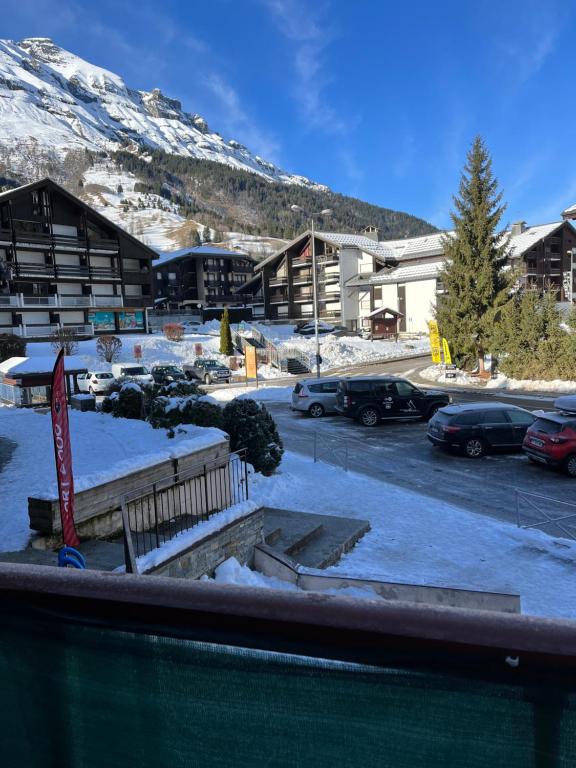 a parking lot with cars parked in front of a building at Combettes Studio Apartment in Les Contamines-Montjoie