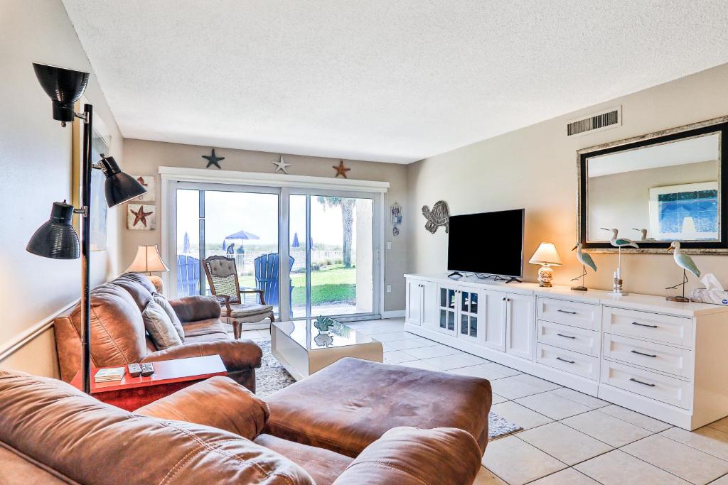 een woonkamer met een bank en een televisie bij Crescent Sandpiper 103 Steps From The Beach in St. Augustine