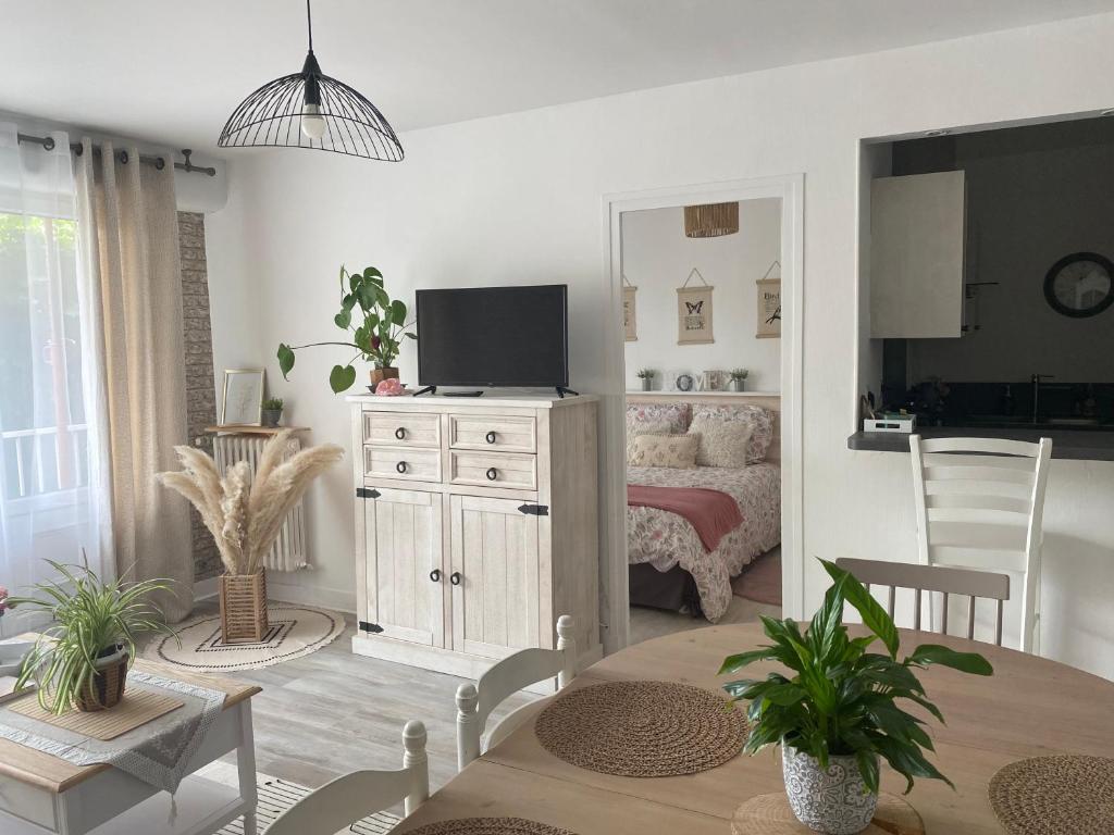 a living room with a television and a bedroom at L’appart in Lisieux