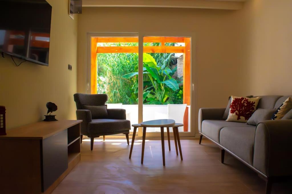 a living room with a couch and a table and a window at Cozy apartment with balcony in Bodrum City