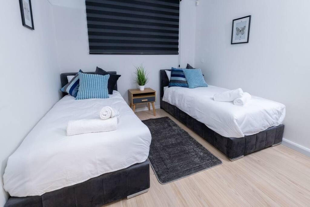 two beds in a room with blue and white at O&O Group - The SeaGate Estate suites - Suite 2 in Rishon LeẔiyyon