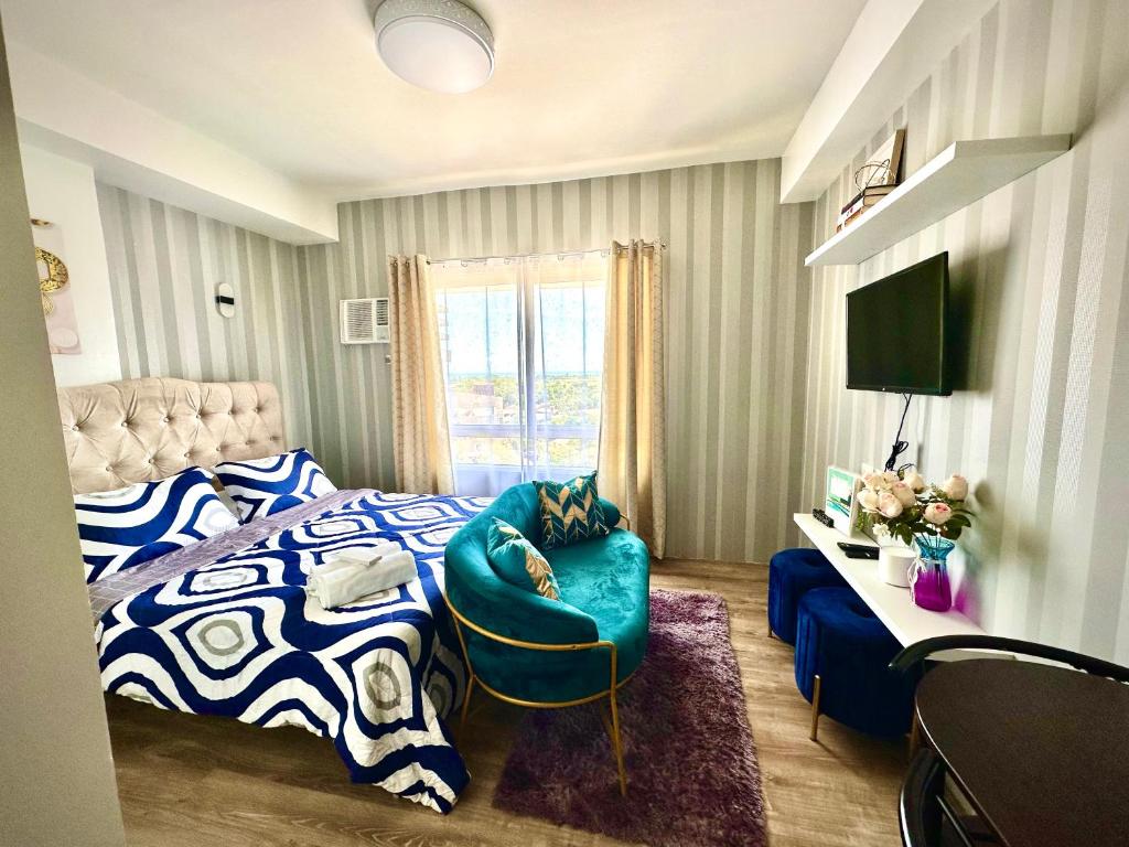 1 dormitorio con 1 cama y 1 silla azul en Lovely Studio Condominiums at Mesavirre Garden Residences Bacolod, en Bacolod