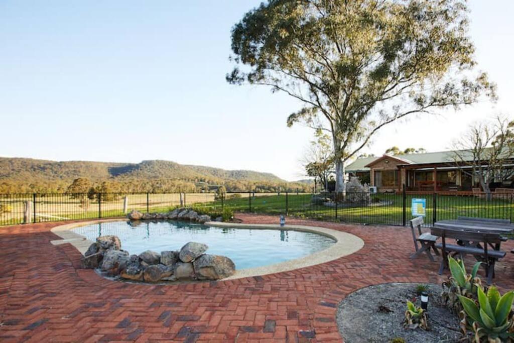 a backyard pool with a fire pit and a picnic table at Peppercorns Riverside Farm Stay in Clarence Town