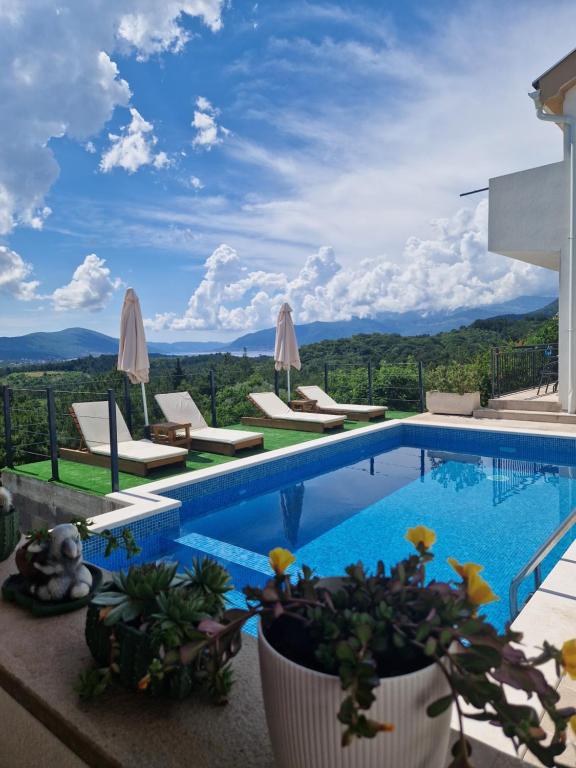 a swimming pool with chairs and a view of the mountains at La Mer Apartments Kotor in Kotor