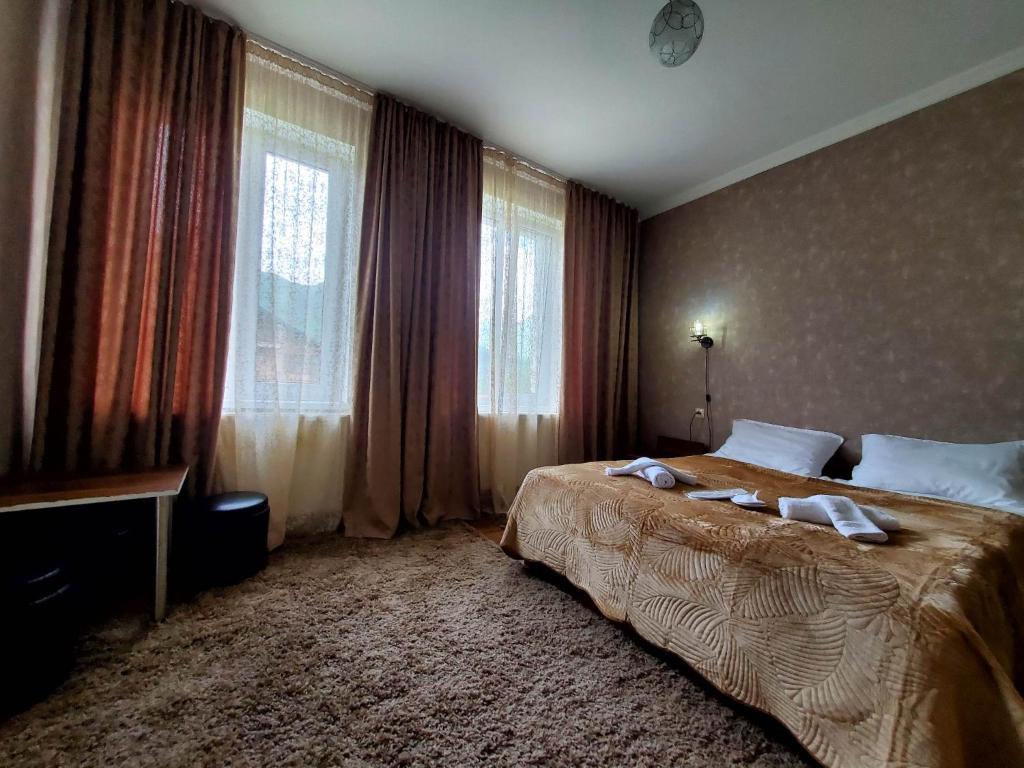 - une chambre avec un grand lit en face des fenêtres dans l'établissement Kazbegi Guest House, à Kazbegi