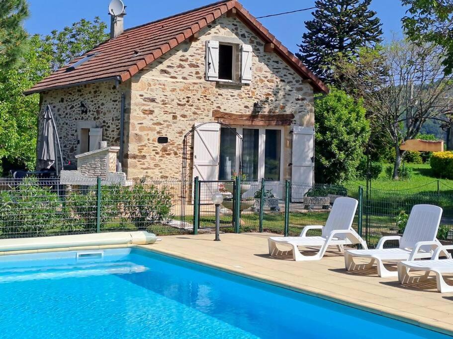 uma casa com piscina e duas cadeiras e um edifício em Maison Landes - Gite 4 personnes em Latouille-Lentillac
