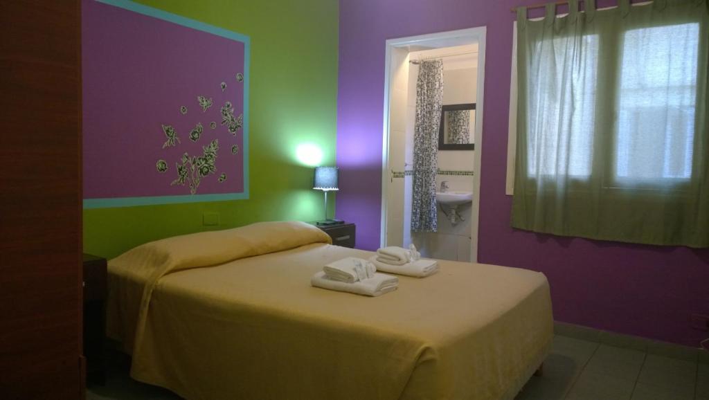 a bedroom with a bed with towels on it at Koten Hotel in Buenos Aires