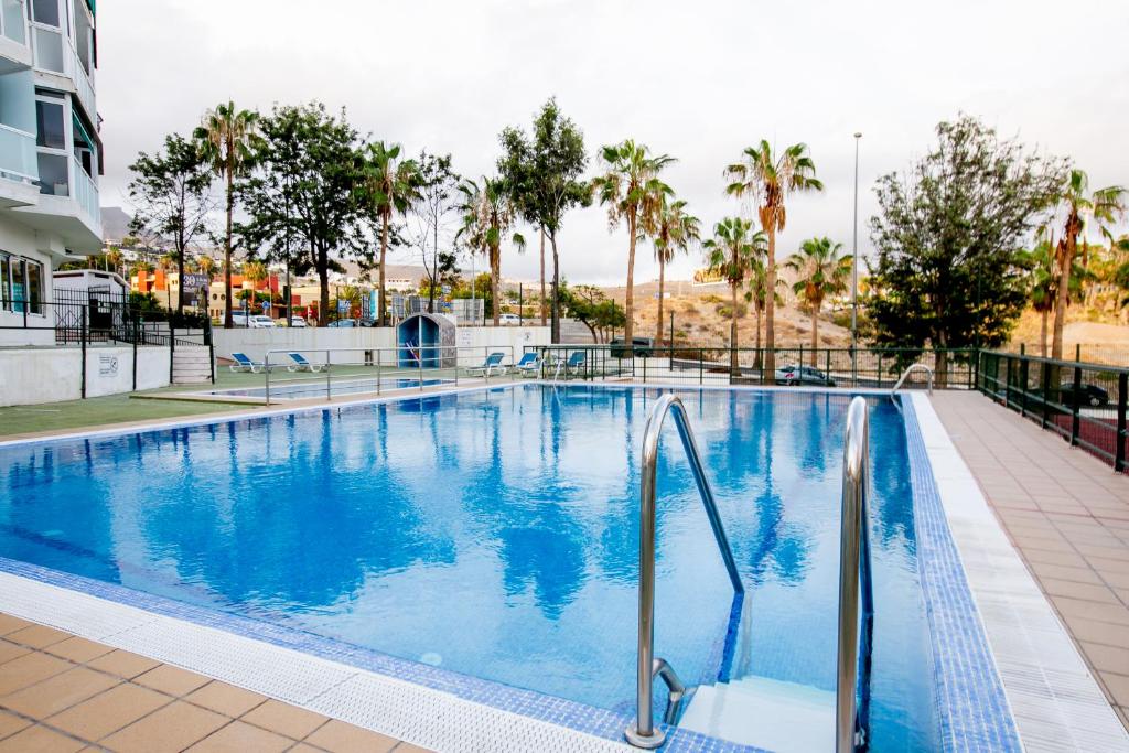 une piscine dans un hôtel avec des palmiers dans l'établissement 313 Comfortable! LasAmericas, Swimming Pool,Wi Fi, à Playa de las Americas
