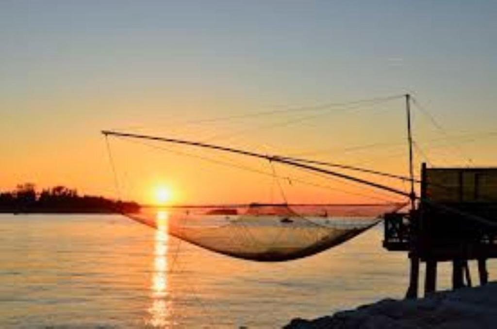 um barco sentado na água ao pôr do sol em Ada home em Veneza