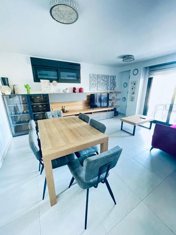 a living room with a wooden table and chairs at Arenal Dream The Beachfront Paradise in Jávea