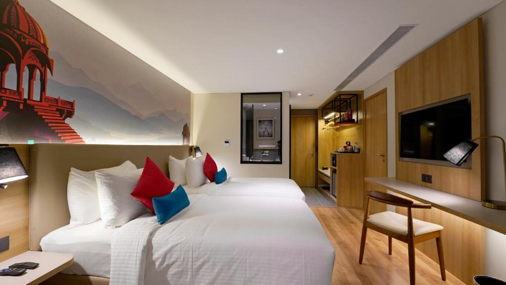 Habitación de hotel con 2 camas y escritorio en Aiden by Best Western Hennur, en Bangalore